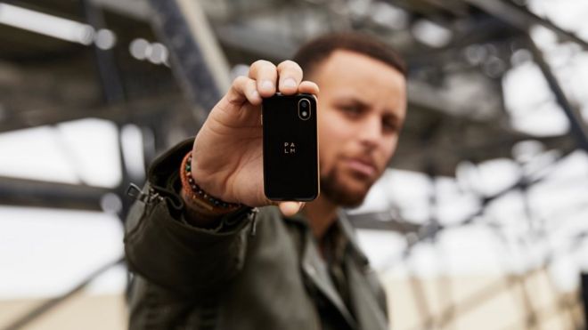 Stephen Curry sosteniendo el mini teléfono Palm